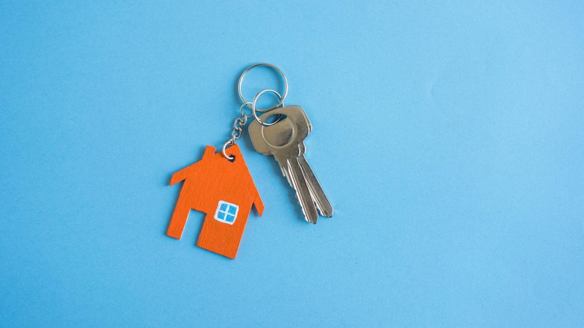 Een sleutel met een sleutelhanger van een huisje