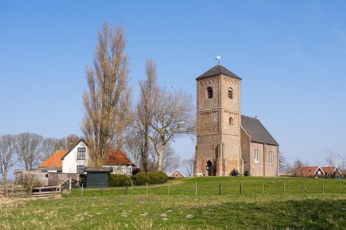 Foto van een kerk op een groene heuvel