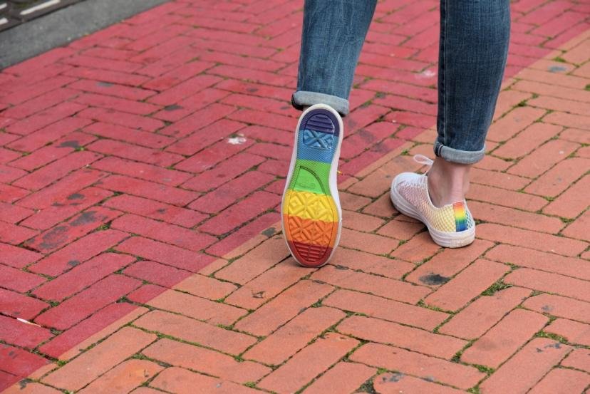 Afbeelding: foto, schoenen met de regenboog op de zolen, alsmede twee van de kleuren stenen van regenboog-bestrating.
