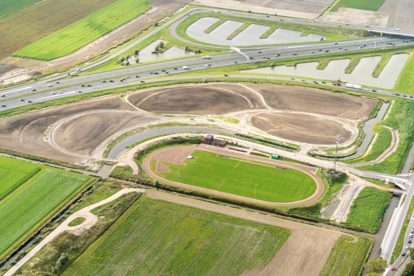Luchtfoto Badhoevedorp met atletiekbaan en Park De Veldpost