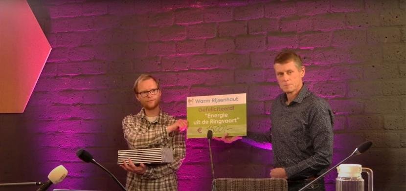 Maurice (links) en Wim, winnaars van Warm Rijsenhout, ontvangen een cheque van 15.000 euro. 
