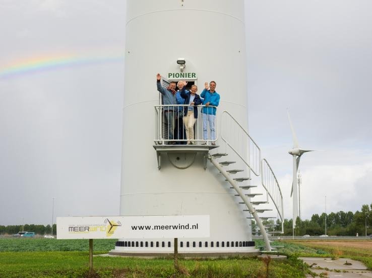 Afbeelding: foto van Charlotte en medewerkers bij een windturbine, genaamd De Pionier. Foto: Jur Engelchor 