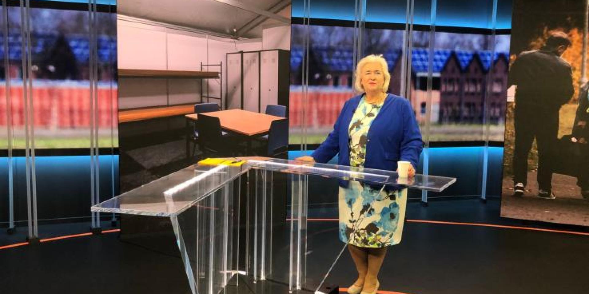 Burgemeester Marianne Schuurmans achter een desk in de studio