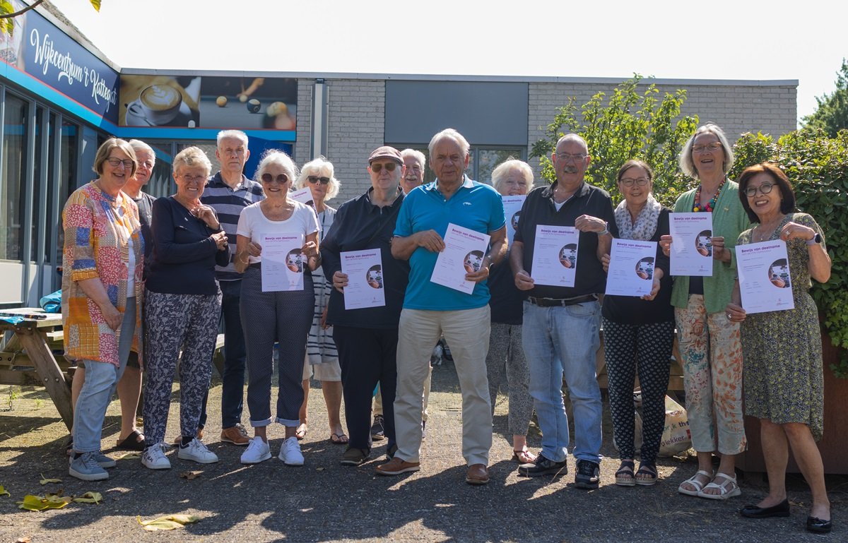 Groepsfoto van zo'n twintig mensen die een certificaat omhoog houden voor wijkcentrum t Kattegat 