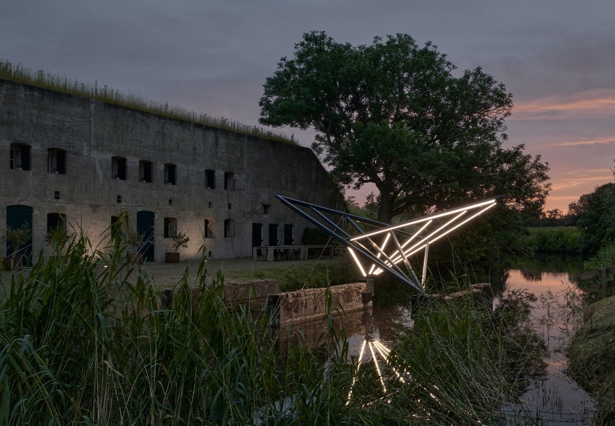 Het verlichte kunstwerk voor het Fort van Hoofddorp bij het vallen van de avond
