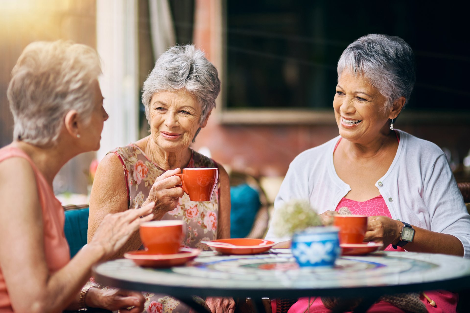 Drie dames drinken koffie samen.