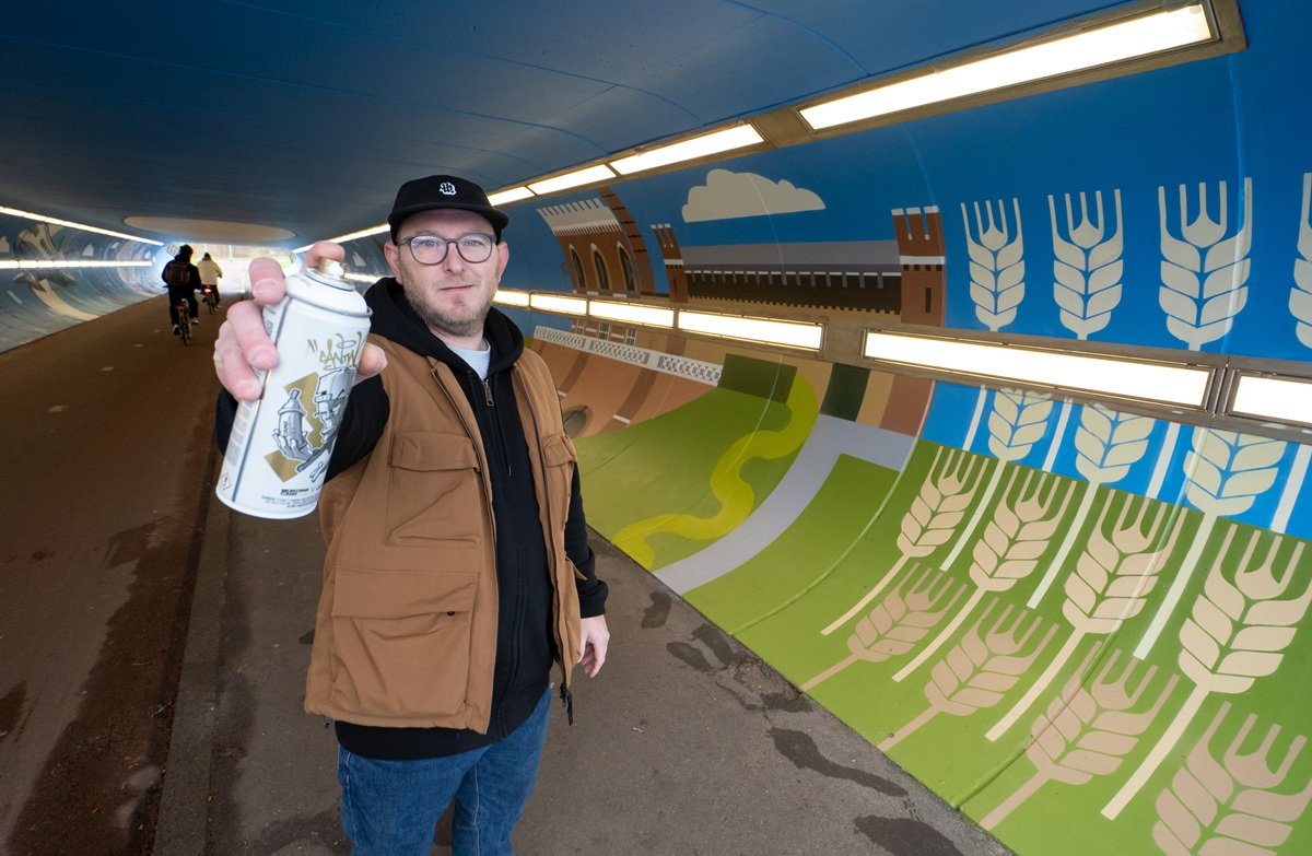 Daan Wille voor zijn streetart in de fietstunnel.