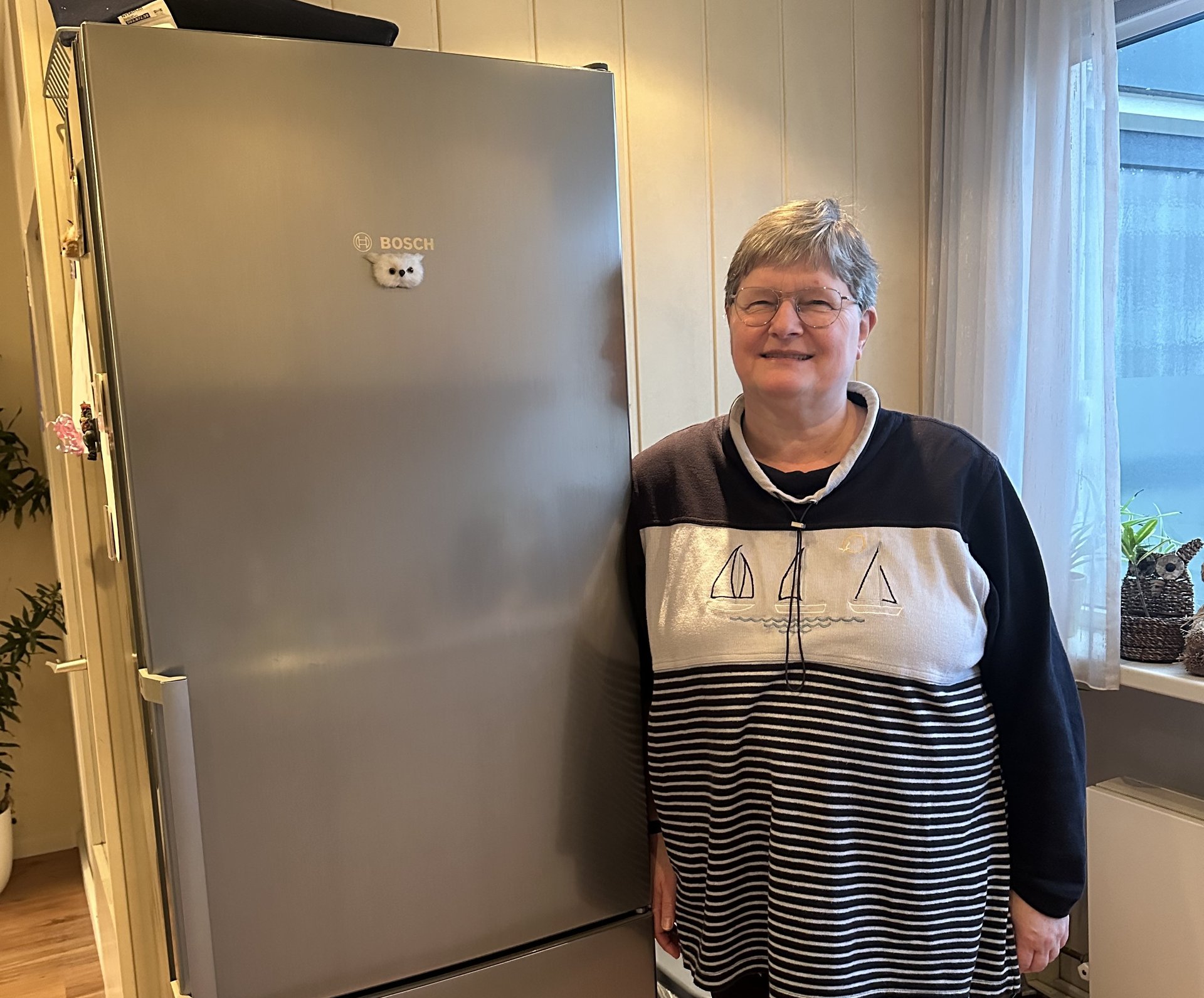 Astrid naast haar nieuwe koelkast.