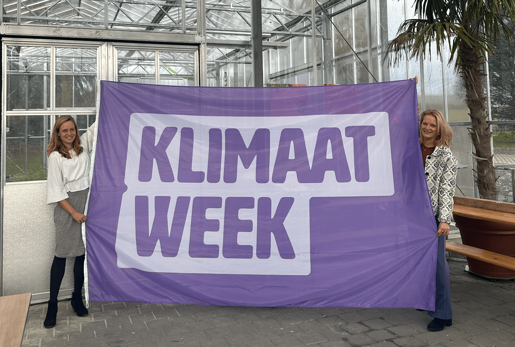 Wethouder Charlotte van der Meij en Karen Meinhardt, directeur van NMCX, met de klimaatweek-vlag. Foto: Gemeente Haarlemmermeer