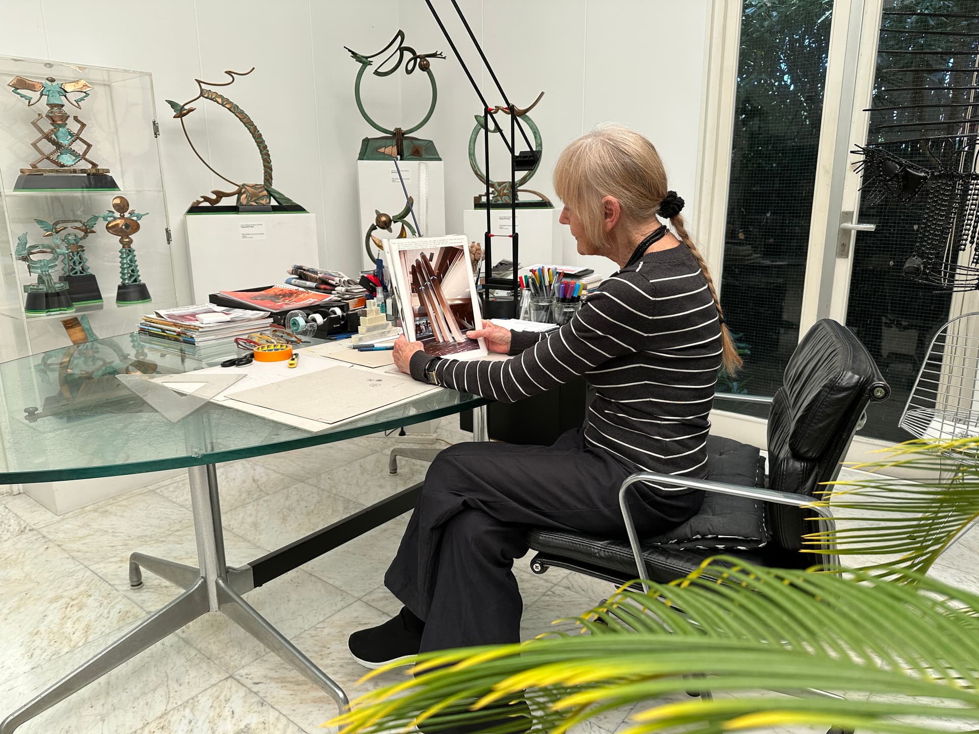 Kunstenares Marja de Boer Lichtveld in haar atelier met een foto van het kunstwerk
