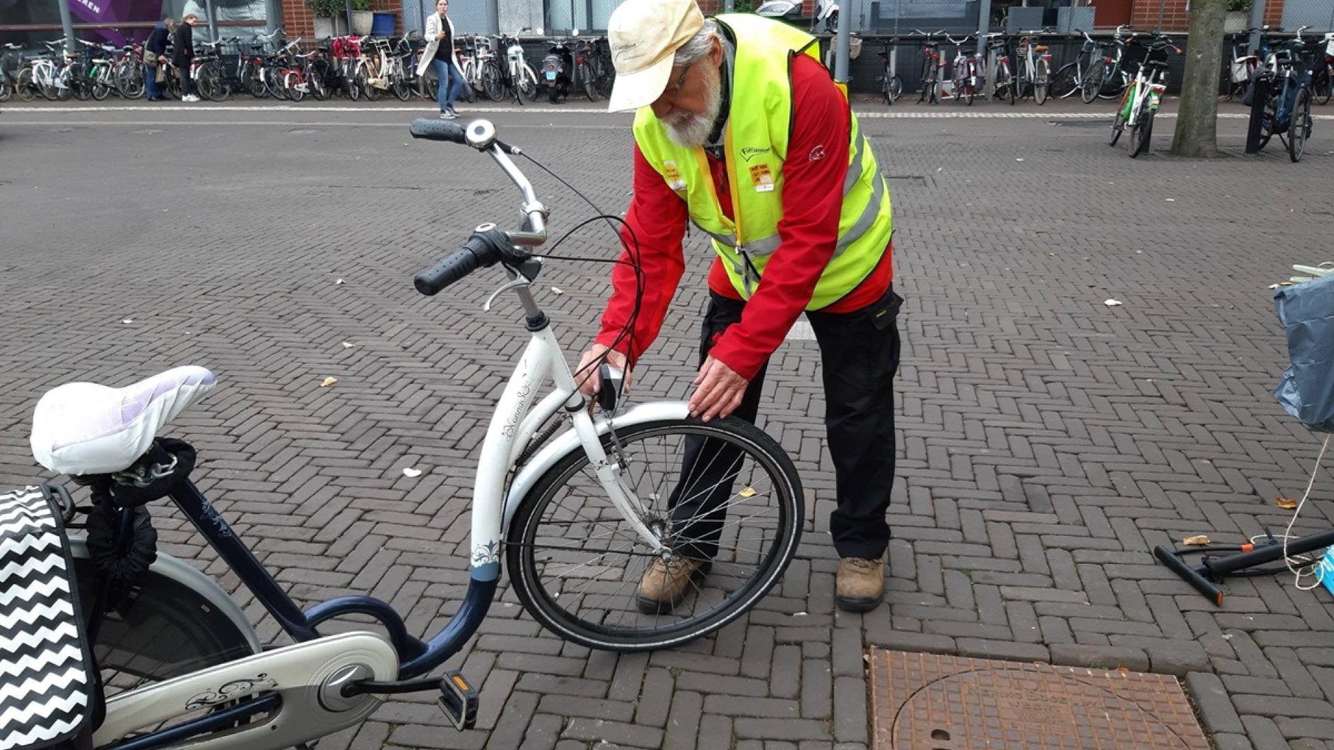 Een vrijwilliger van de Fietsersbond check fietsverlichting